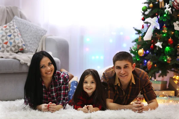 Happy family on the floor in the decorated Christmas room — Stock Photo, Image