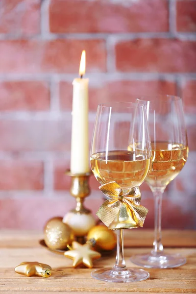 两杯酒用蜡烛和圣诞玩具上的背景墙上 — 图库照片