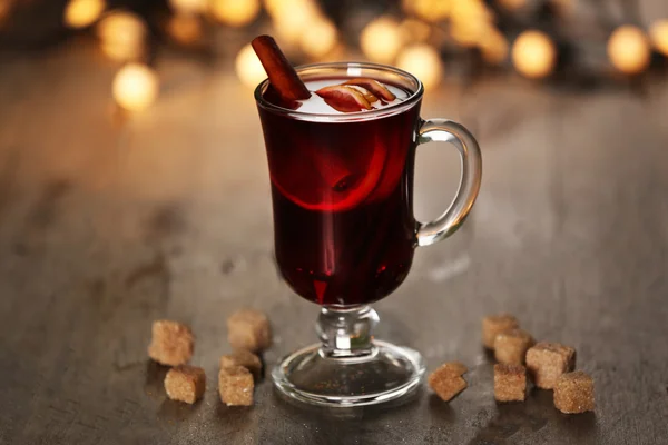 Mulled wine with spices and Christmas tree on wooden background — Stock Photo, Image