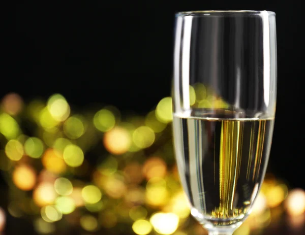 A glass of champagne with bokeh on dark background — Stock Photo, Image