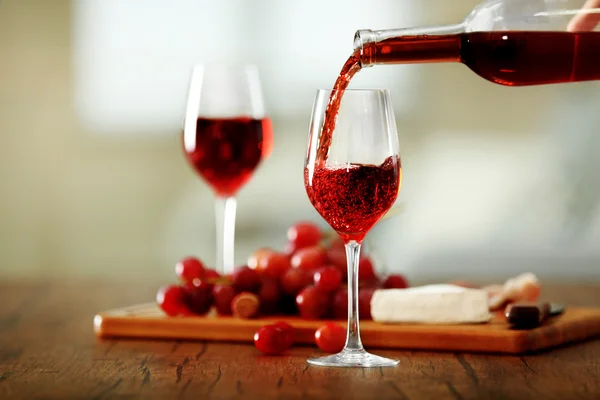Verter vino rosado de la botella en la copa de vino — Foto de Stock