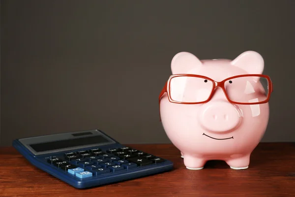 Piggy bank met glazen en rekenmachine — Stockfoto