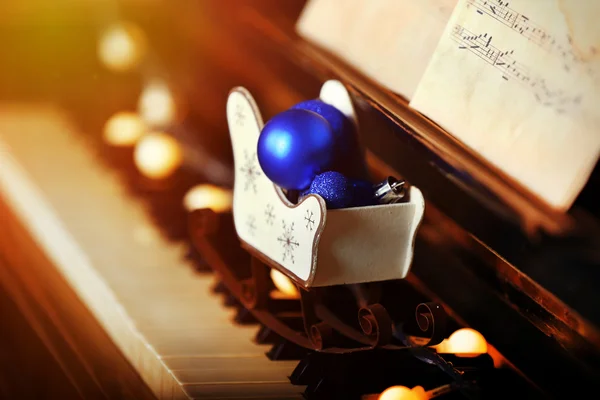 Tasti per pianoforte decorati con luci decorative e palle, da vicino — Foto Stock