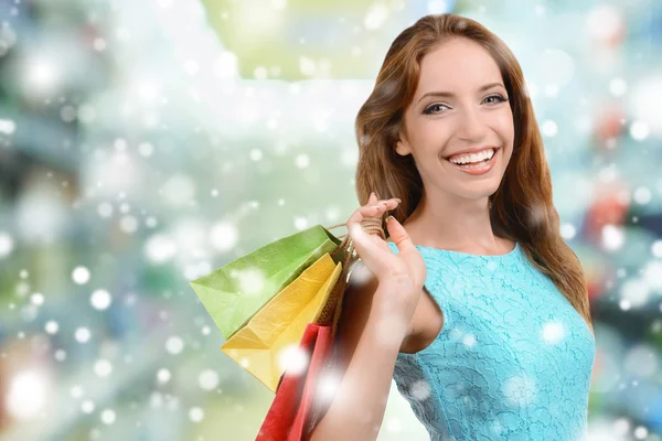 美丽的年轻女子，与袋购物中心的中心地带，在雪的效果 — 图库照片