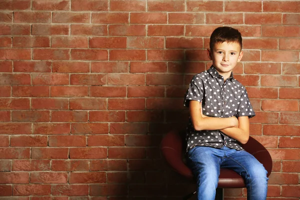 レンガ壁の背景にかわいい男の子。子供ファッションのコンセプト — ストック写真