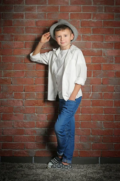벽돌 벽 바탕에 귀여운 작은 소년. 아이 패션 개념 — 스톡 사진