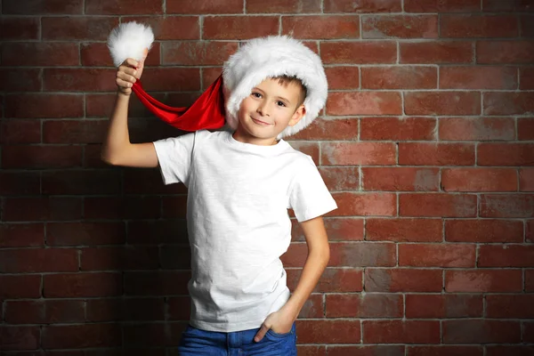 Menino bonito com caixa de presente no fundo da parede de tijolo . — Fotografia de Stock