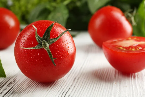 Cherry tomatoes with basil on wooden table close up — Stock Photo, Image