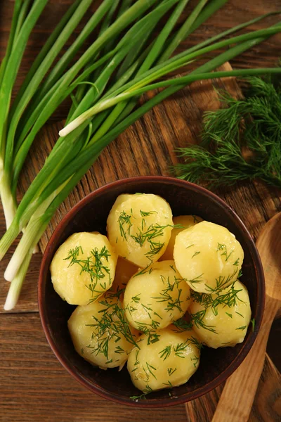 Las patatas cocidas con la verdura en la escudilla a la mesa se acercan —  Fotos de Stock