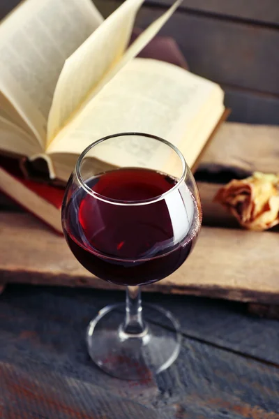 Hermosa composición con copa de vino con libros antiguos en la mesa de cerca —  Fotos de Stock