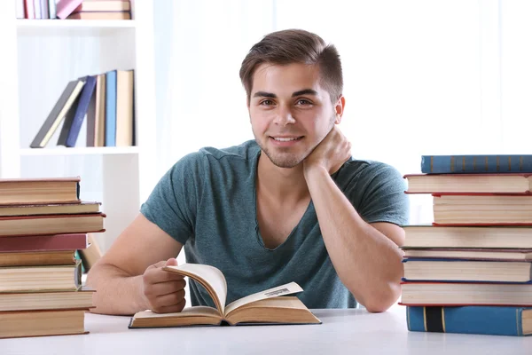 Młody człowiek czytania książki w tabeli — Zdjęcie stockowe