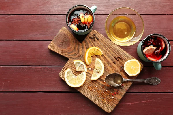 Glühwein im Becher mit Zitrusfrüchten auf Holzgrund, Nahaufnahme — Stockfoto