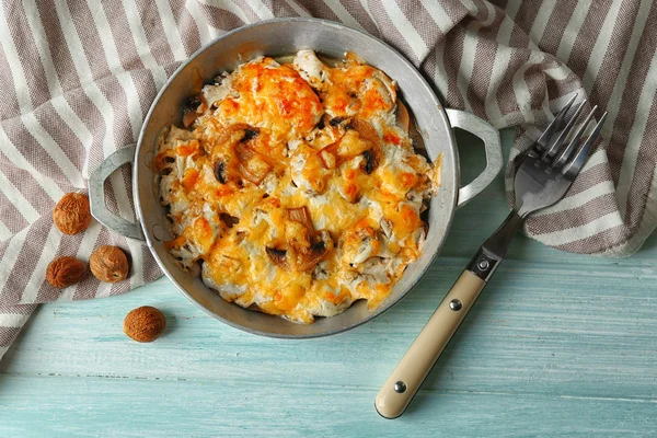 Roasted mushrooms, chicken and cheese gratin in pan, on wooden background — Stock Image Roasted mushrooms, chicken and cheese gratin in pan, on wooden background Stock Picture
