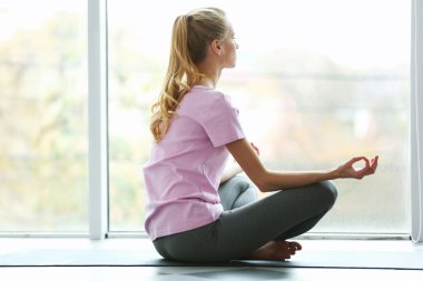 Genç kadın karşı pencere meditasyon