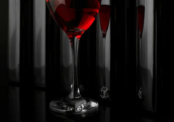 Красный бокал вина против бутылок подряд на черном фоне, закрыть — стоковое фото