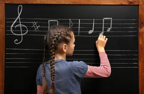 Chica escribiendo notas musicales —  Fotos de Stock