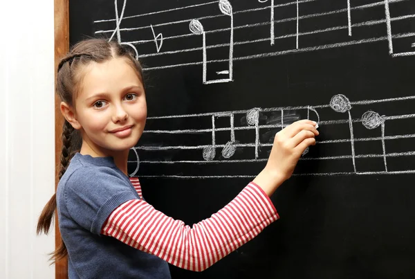 Mädchen schreibt Noten — Stockfoto