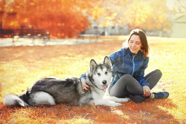 Woman sitting with her dog in park — Stock Photo, Image