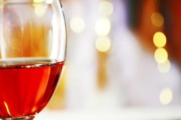 A glass of pink wine on blurred lighted background — Stock Photo, Image