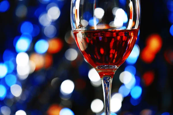 Un bicchiere di vino rosa su sfondo sfocato illuminato — Foto Stock