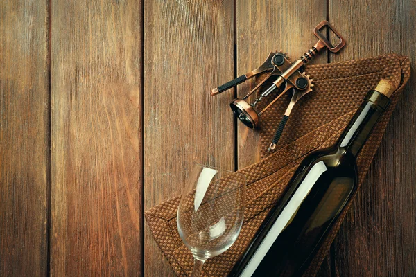 Bottiglia di vino con calice e cavatappi su fondo di legno — Foto Stock