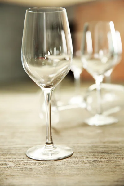 Пустые бокалы для вина на деревянном столе на размытом фоне — стоковое фото