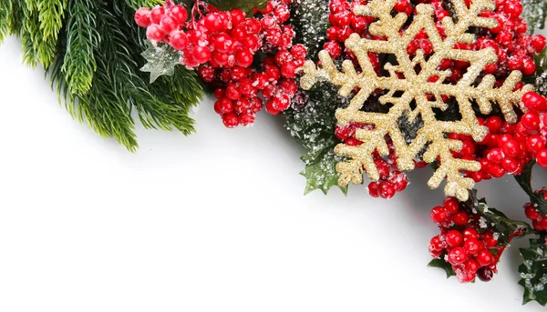 Rama de árbol de Navidad con bayas rojas y copo de nieve dorado sobre fondo blanco — Foto de Stock