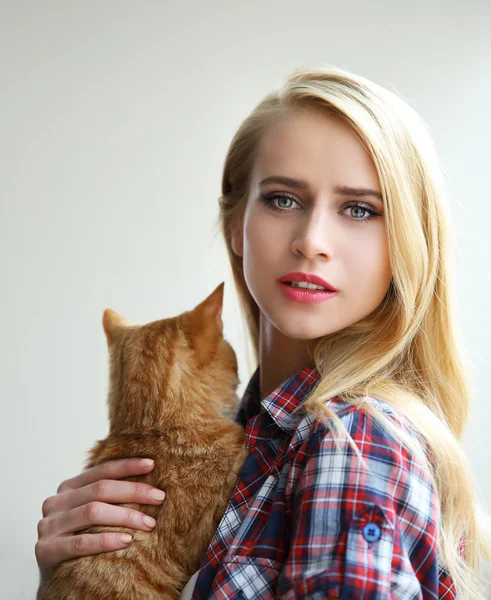 Jeune femme posant avec chat rouge dans les mains, gros plan — Photo