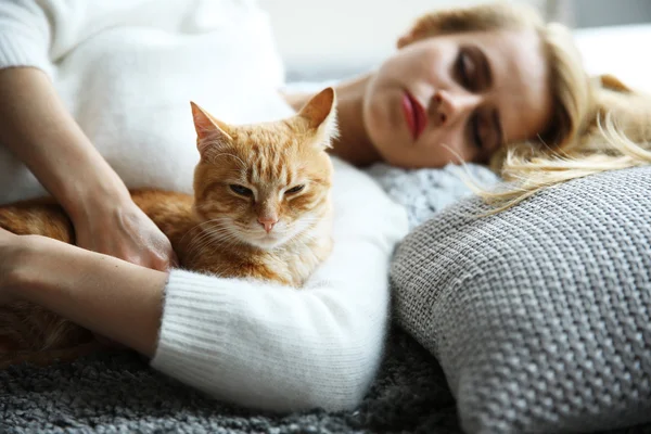 Attractive woman laying with red cat — Stock Photo, Image