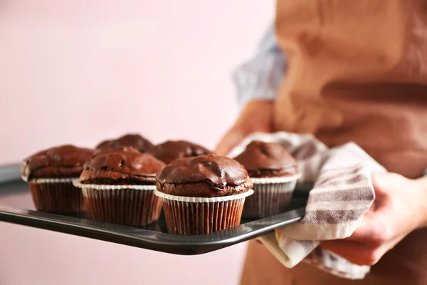 Домохозяйка держит духовку-поднос с шоколадными кексами, закрыть — стоковое фото