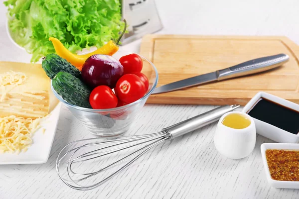 Кухонные принадлежности и ингредиенты для салата на столе, на светлом фоне — стоковое фото
