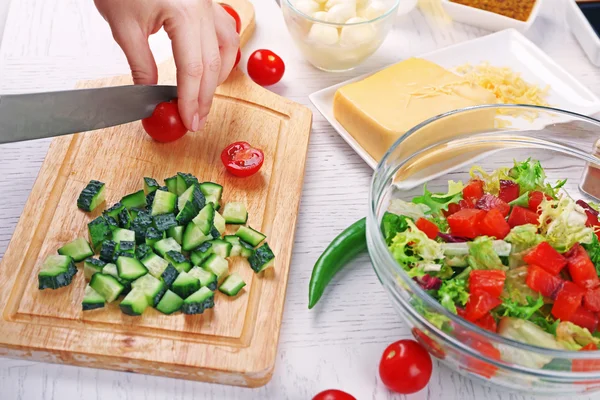 Las manos femeninas cortan hortalizas para la ensalada, a la cocina —  Fotos de Stock