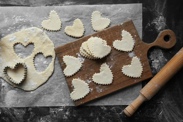 Biscotti a forma di cuore crudi su un tavolo — Foto Stock