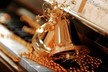 Altın Noel süsleriyle süslenmiş piyano tuşları, kapatın.