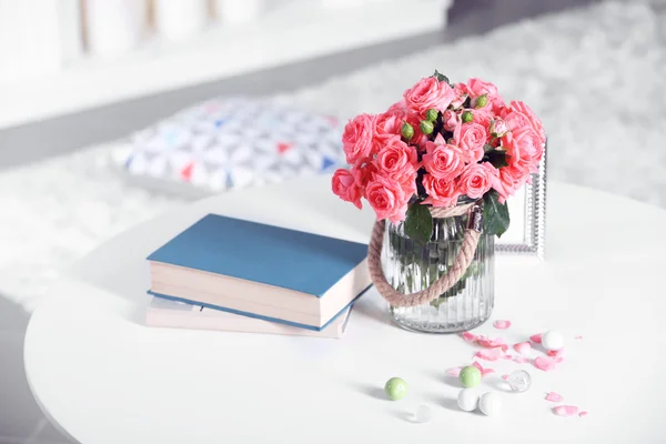 Bela rosa em vaso na mesa no quarto — Fotografia de Stock