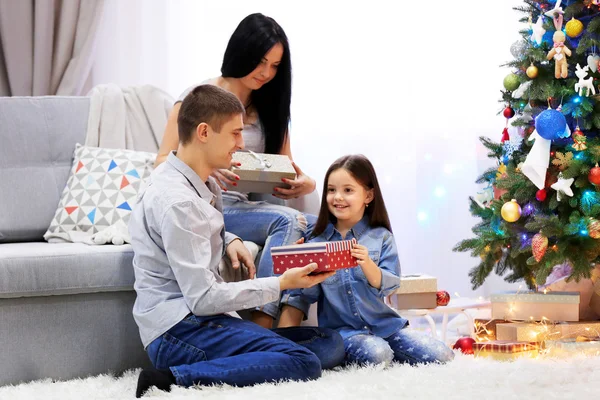 Familia feliz con regalos en la habitación de Navidad decorada — Foto de Stock