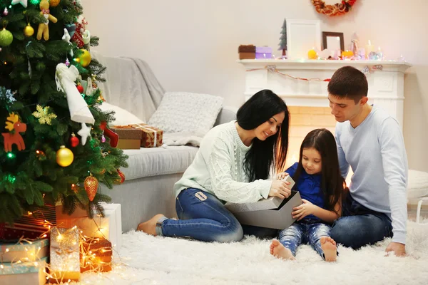 Ευτυχισμένη οικογένεια στο πάτωμα με τα δώρα στο διακοσμημένο δωμάτιο Χριστούγεννα — Φωτογραφία Αρχείου