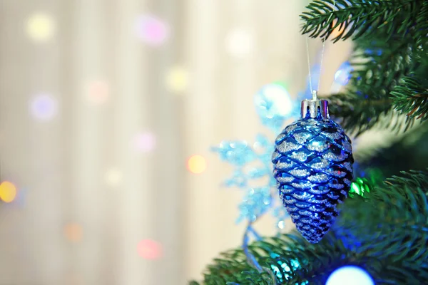 Christmas toy on a fir tree over blurred background, close-up — Stock Photo, Image