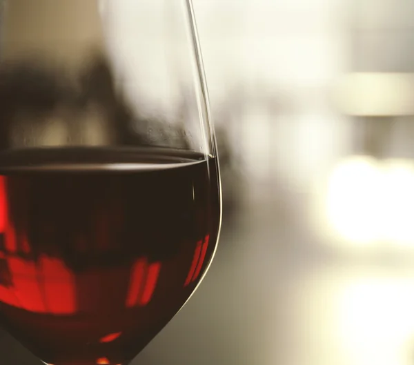 Glas Rotwein auf verschwommenem Hintergrund — Stockfoto