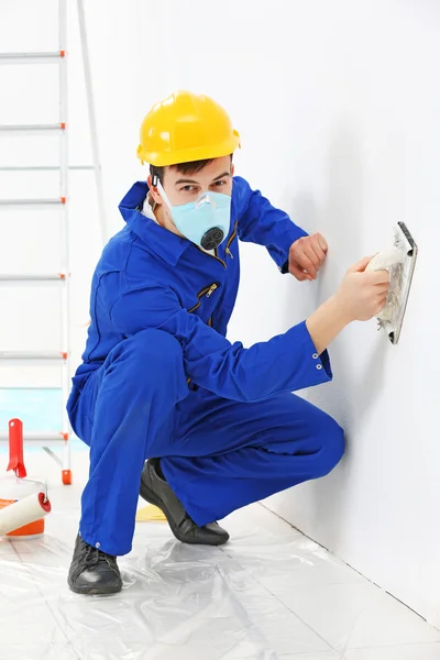 Trabajador renovando apartamento en fondo de pared — Foto de Stock