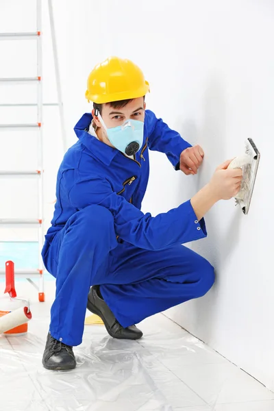 Trabajador renovando apartamento en fondo de pared —  Fotos de Stock