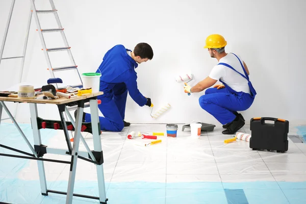 Workers renewing apartment on wall background — Stock Image Workers renewing apartment on wall background Royalty Free Stock Images