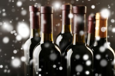 Üst üste kar etkisi üzerinde ahşap arka plan üzerinde şarap şişeleri