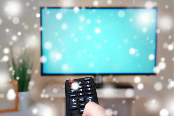 Перегляд телевізора і використання пульта дистанційного керування над ефектом снігу — стокове фото