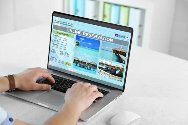 Online kitap otele dizüstü bilgisayar kullanan adam