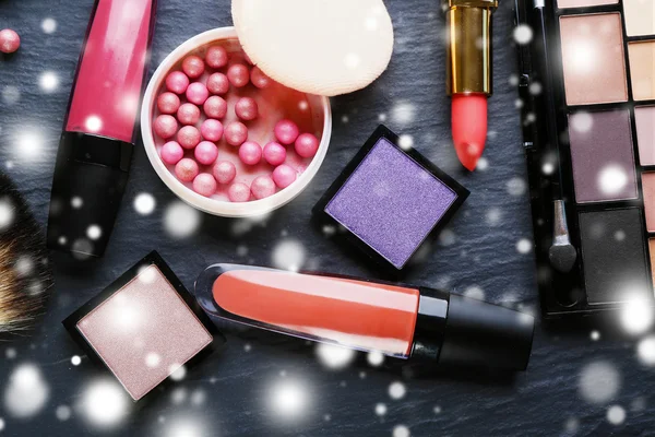 Cosmetics on grey  background over snow effect — Stock Photo, Image