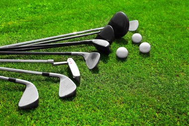 Bir satır ve topları bir yeşil çimenlerin üzerinde farklı golf kulüpleri