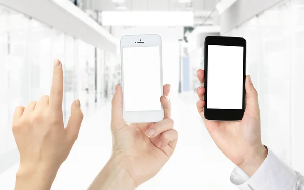 Mani in possesso di smartphone in bianco e nero su sfondo chiaro — Foto Stock