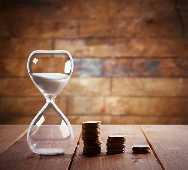 Antique Hourglass with coins Stock Image