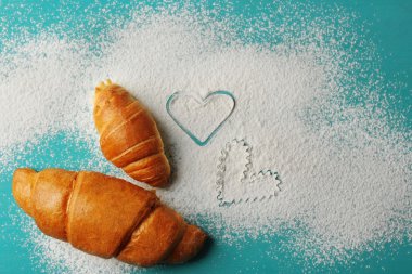 Un ve ahşap zemin üzerine taze kruvasanlar kalp